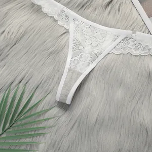 Close-up of white floral lace G-string featuring round metal buckles and cotton crotch