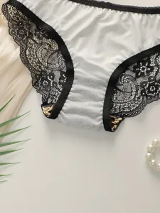 Close-up of elegant ivory satin panties with black floral lace and leopard print accents