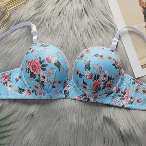 Floral print lace trim bra in light blue with adjustable straps on plush grey background