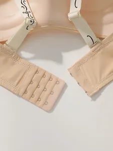 Détail de la fermeture à agrafes quatre rangées au dos d'un soutien-gorge push-up beige