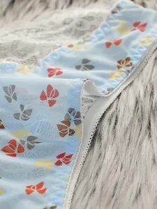 Dettaglio di slip in pizzo azzurro con stampa a farfalle e ricami floreali fini