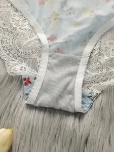 Dettaglio ravvicinato di slip in mesh azzurro con stampa floreale su sfondo di peluche