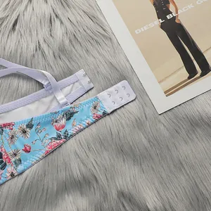 Detail of floral lace bra showing three-row hook and eye closure on soft plush background