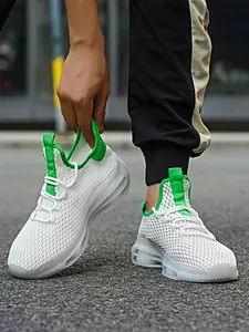 Details van ademende witte mesh-sneakers met groene accenten en een gedempte zool