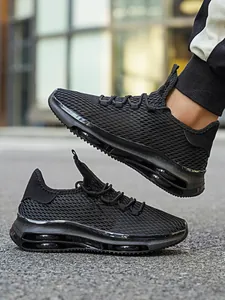 Detail van ademende zwarte mesh sneakers met volledige luchtkussenzool