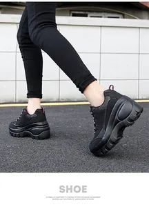 Detail van zwarte platform sneakers voor dames met roze stiksels in buitenomgeving
