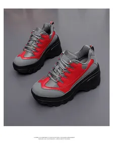 Detail van grijs-rode chunky platform sneakers met antislip zwarte rubberen zool