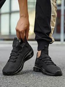 Detail van zwarte mesh hardloopsneakers met een zichtbaar luchtkussen over de hele lengte