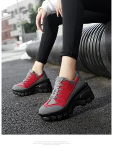 Detail van rode en grijze platform sneakers met dikke zwarte zolen op straat
