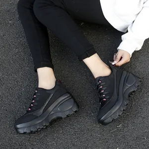 Dames mesh platform sneakers in zwart met roze accenten op een asfaltweg