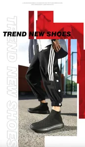 Street style shot of black knit sock sneakers with thick cushioned soles on outdoor pavement