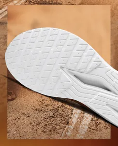 Macro view of white rubber outsole with diamond anti-slip texture and grip grooves