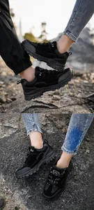 Nahaufnahme der Gummisohle und des verstärkten Stoffes der schwarzen Wanderschuhe