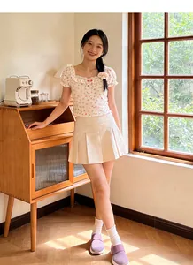 Lifestyle shot of woman in floral top and pleated skirt with comfy platform casual shoes
