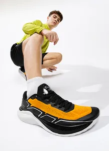 Dynamic low-angle shot of orange and black mesh running shoes with thick cushioned soles