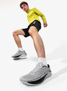 Dynamic low-angle shot of retro thick-sole running shoes in grey and white mesh