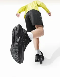 Dynamic low-angle view showing non-slip sole texture of black mesh running shoes