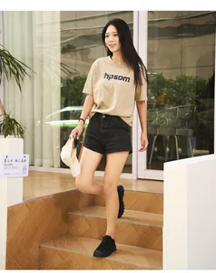 Close-up of a khaki round-neck T-shirt paired with black high-waisted denim shorts