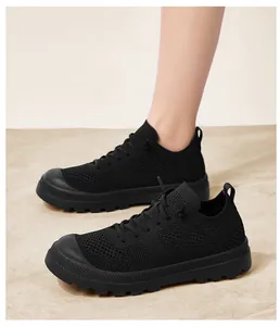 Close-up of black breathable mesh sneakers with thick anti-slip rubber soles and laces