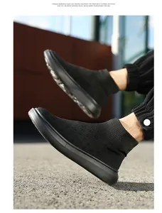 Detail of black knitted sock sneakers showing elastic diamond weave texture and thick rubber sole