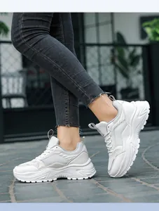 Detalle de zapatillas blancas con plataforma, paneles de malla y suela retro gruesa