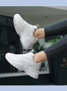 Detalle de zapatillas blancas de plataforma con paneles de malla y cuero sintético