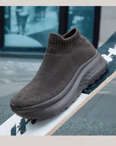 Dettaglio di sneaker a calza in maglia marrone scuro con suola spessa ammortizzata su skate