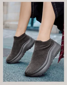 Dettaglio di sneaker a calzino in maglia grigio scuro con suola spessa e fodera calda