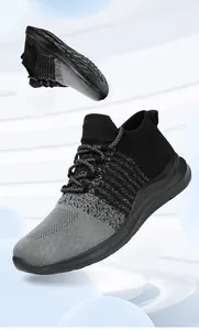 Detail van ademend gebreid bovenwerk en antislipzool op grijze sportieve loopschoenen