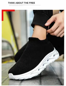 Side view of black knit sock sneaker featuring a white hollowed-out wavy thick sole