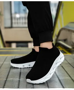 Macro side view of breathable black knit mesh sneakers with thick wavy white soles