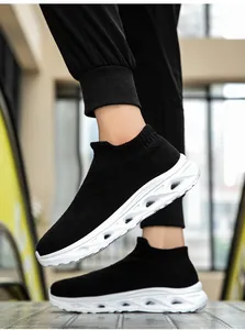 Men's black knit sock sneakers with thick white hollow sole on urban street background