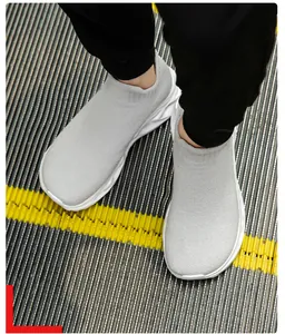Macro detail of breathable fly-knit grey sock sneaker on an escalator step