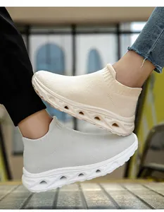 Close-up of knit sock sneakers in beige and light grey with hollow shock-absorbing soles