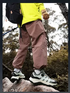 Scarpe da trekking con sistema di allacciatura rapida su sfondo di foresta e rocce