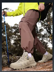 Dettaglio delle scarpe da trekking beige con sistema rotante e bastoncini nel bosco