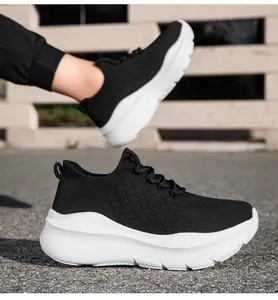 Détail de baskets en maille respirante noire avec semelle blanche ondulée et tirette