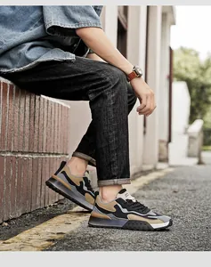 Detail view of khaki patchwork breathable sneakers with thick non-slip soles on street