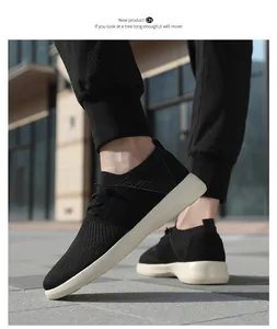 Vista laterale di sneaker in maglia nera traspirante con suola bianca in città
