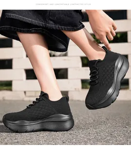 Vue latérale de baskets en maille noire respirante avec semelles épaisses sur un modèle