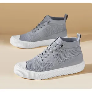 Detail of grey knitted high-top sock sneakers with textured mesh and white striped rubber sole