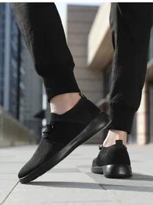 Dettaglio della maglia traspirante e suola spessa su scarpe da passeggio sportive nere