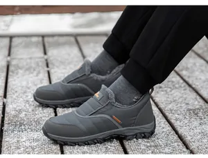 Détail de chaussures d'hiver grises avec doublure en peluche sur un sentier enneigé