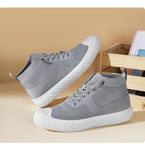 Detail of grey knitted high-top sneakers featuring breathable fabric and white rubber sole