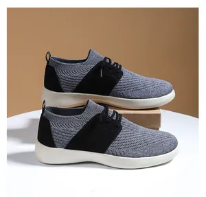 Dettaglio scarpe da ginnastica in maglia grigia traspirante con inserti in pelle scamosciata nera