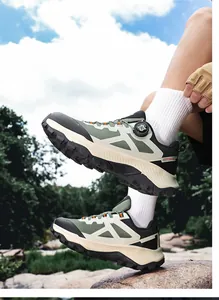 Detail of army green outdoor hiking shoe with rotating knob lacing system on rocky ground