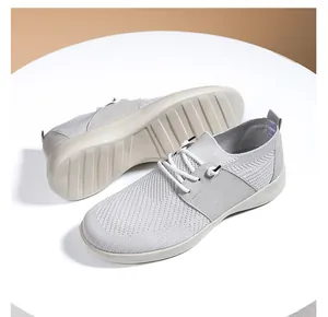 Dettaglio macro del tessuto fly-knit grigio traspirante e del design stringato della scarpa