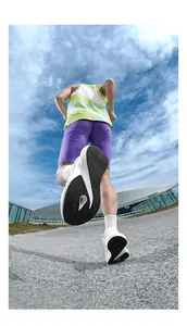 Action shot of breathable white running shoes with non-slip black outsoles on a sunny road