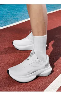 Detail of white mesh running shoe on a track featuring a thick cushioned midsole