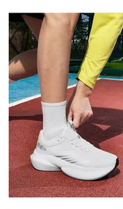 Detail of white mesh running shoes with thick cushioned soles and Lightning Pro logo
